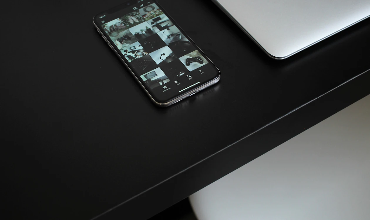 Laptop and smartphone on a dark desk